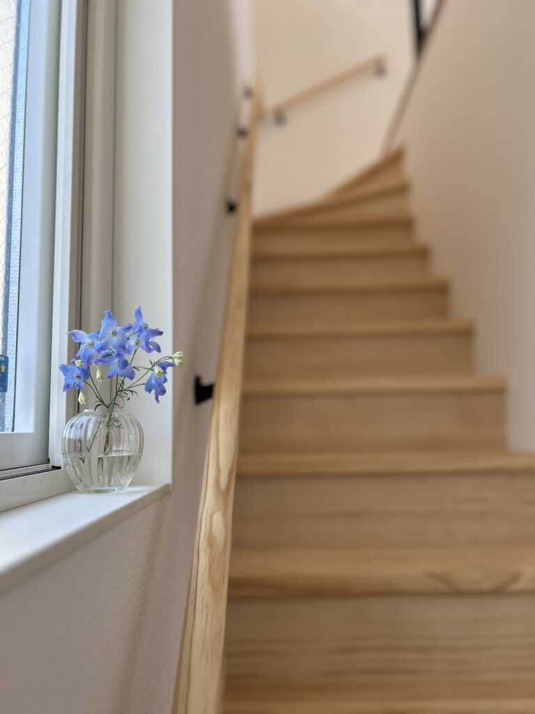 木製階段とガラスの瓶に活けた青い花 