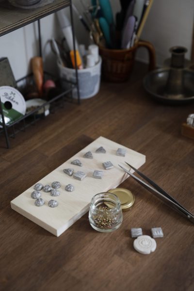 アトリエのカウンターの上にオーブン粘土のアクセサリーが置いてある写真。