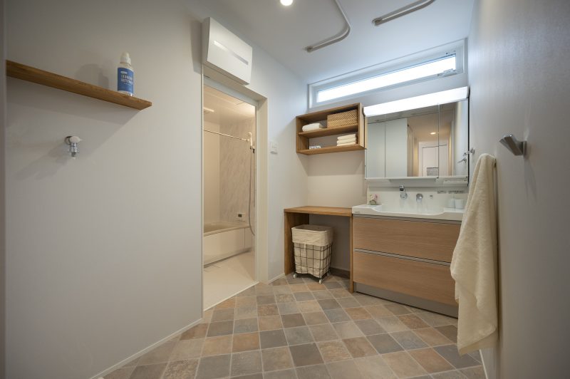 洗面脱衣室にある洗面台と可動式の物干しバーがある写真