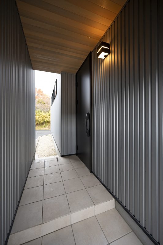 玄関までのアプローチは視界を遮り、開くと閉じるを兼ね備えたデザイン