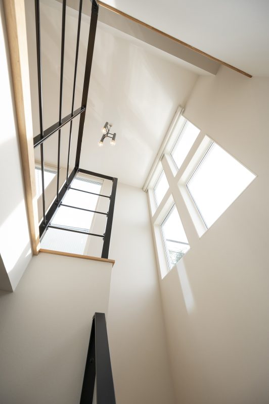 階段上の吹き抜けに明るい光が入り込んでいる写真