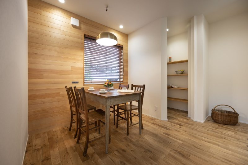 アクセントウォールで無垢の板貼りを施したダイニング