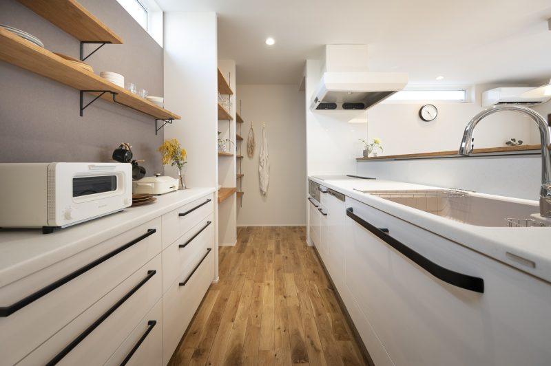 白いキッチンに黒のアイアン取手が目立つ写真