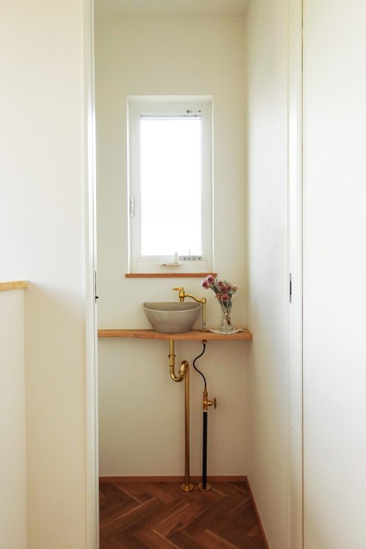 トイレの角に小さな手洗い器がある写真