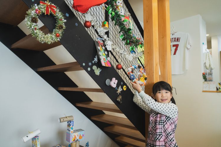 小さい女の子が自分で作った工作を見せてくれている様子