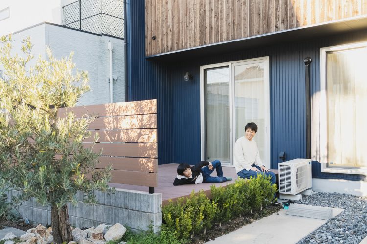 ウッドデッキでお父さんと息子がくつろいでいる様子